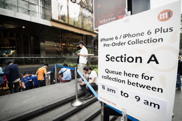 Apple fans queue up outside an M1 store in Singapore for the new iPhone.