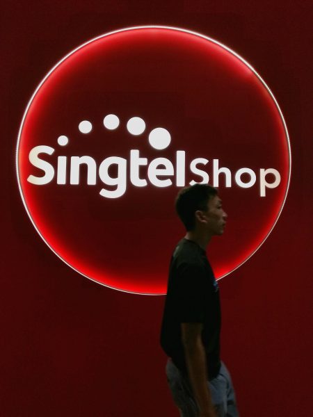 A man walks past a Singtel shop in Singapore. Wilson Wong for Techgoondu.