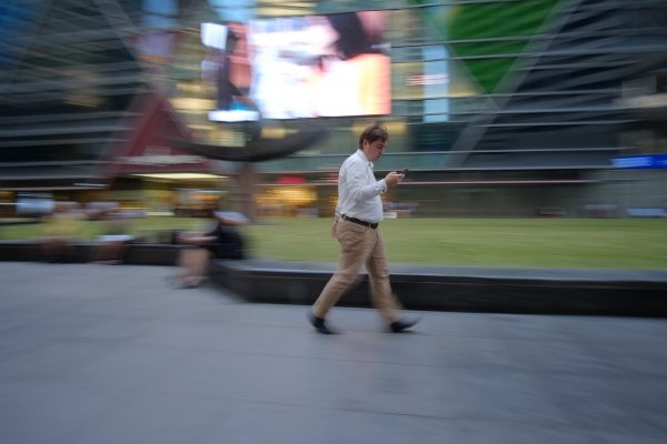 A man walks while staring at his phone at Singapore's Raffles Place in March 2016. PHOTO: Wilson Wong for Techgoondu